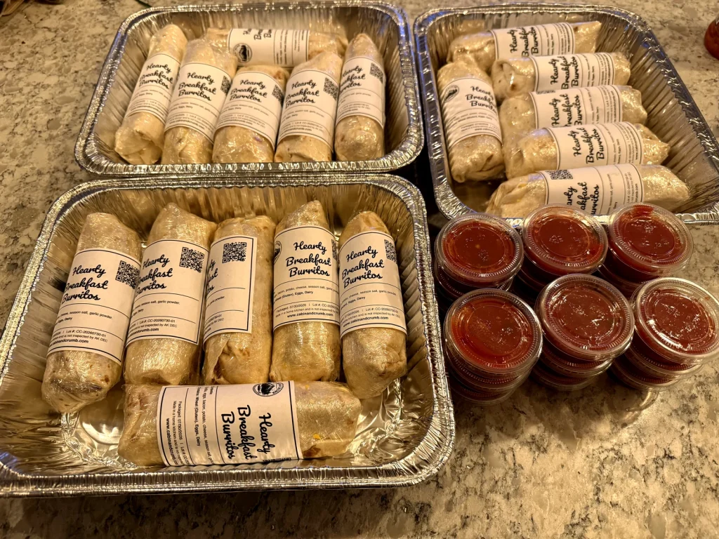 Tray of Cabin & Crumb hearty breakfast burritos wrapped and labeled
